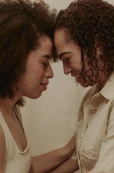 A tender moment between a mother and daughter embracing gently indoors, showcasing love and connection.