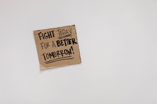 Cardboard sign with motivational quote: 'Fight today for a better tomorrow!' on white background.