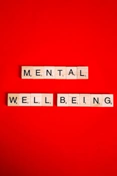 Scrabble tiles spelling 'mental well-being' on a red background, symbolizing mental health.
