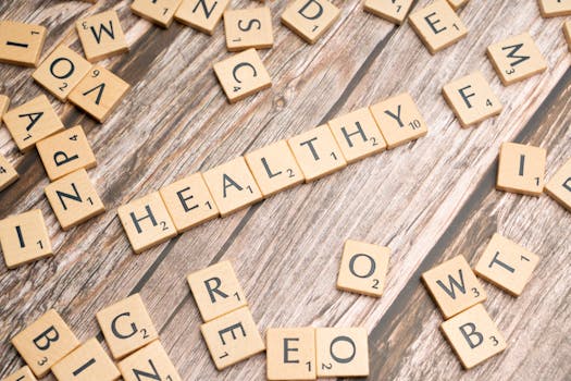 Wooden letter tiles arranged on a wooden surface spelling out 'healthy', symbolizing wellness.